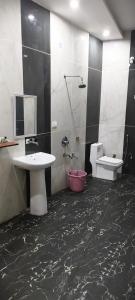 a bathroom with two sinks and a toilet and a mirror at The duggar villa in Jammu