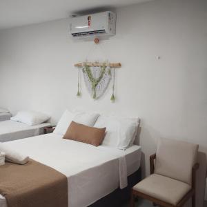 a bedroom with two beds and a heater and a chair at Pousada Mangai in João Pessoa +65 photos