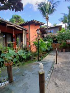 a bird sitting on a pole in front of a house at Espaço Casa Palmar in Barra Grande