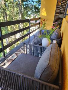 a balcony with couches and a vase on a railing at Friends 2 Vlašić in Vlasic