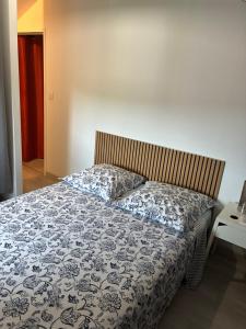 a bedroom with a bed with a blue and white blanket at Gîte de chenieux in Saint-Victor-sur-Loire