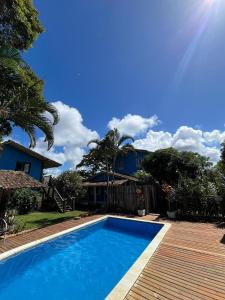 a swimming pool in front of a house at Vila Cizinho in Itaúnas