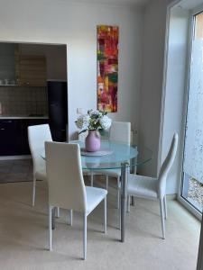 a dining room with a glass table and white chairs at Apartment in Delitzsch +3 photos