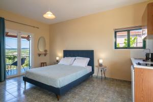 a bedroom with a bed and a kitchen with a balcony at Maria Anastasia Studios in Trapezaki