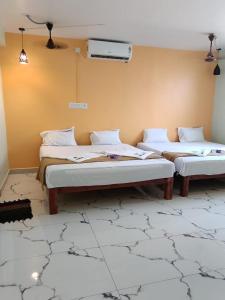 a room with two beds in a room with aperature at Relax Residency in Mandapam