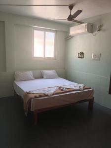 a bed in a room with a ceiling fan at Relax Residency in Mandapam