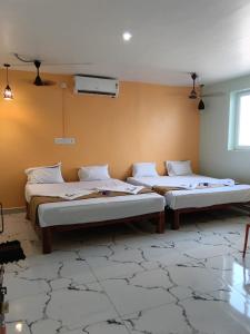 a room with two beds in a room with at Relax Residency in Mandapam
