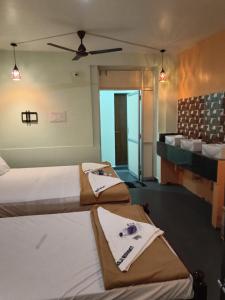 a bedroom with two beds with towels on them at Relax Residency in Mandapam