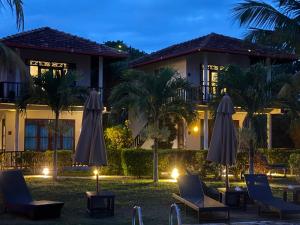 a resort with lawn chairs and umbrellas at night at Ananthaya Beach in Tangalle