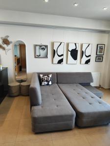 a couch in a living room with paintings on the wall at Vista mare by Oikies Rentals in Neoi Epivates +18 photos