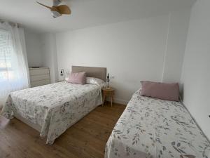 a bedroom with two beds and a ceiling fan at AMANITA VuT in Huerta del Rey