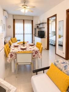 a kitchen and living room with a table and a couch at Residence The Yellow Fish with Pool in Manerba del Garda