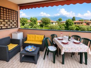 a patio with a table and chairs and a view of mountains at Residence The Yellow Fish with Pool in Manerba del Garda