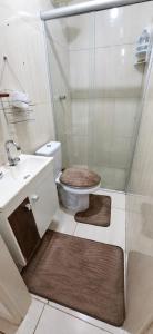 a bathroom with a shower with a toilet and a sink at Pousada da Juh in Campo Grande