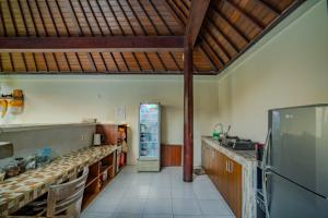 a large kitchen with a refrigerator in a room at Canggu Bagus Guest House in Canggu