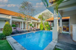a swimming pool in the backyard of a house at Canggu Bagus Guest House in Canggu