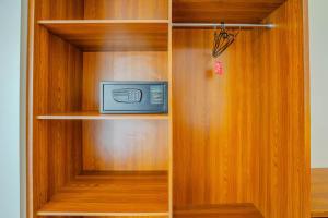 a wooden book shelf with a microwave in it at Canggu Bagus Guest House in Canggu