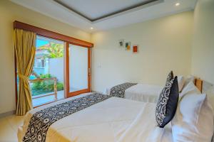 a bedroom with two beds and a large window at Canggu Bagus Guest House in Canggu +23 photos