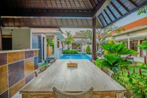 an outdoor dining area with a wooden table and chairs at Canggu Bagus Guest House in Canggu