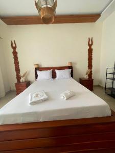 a large bed with two white pillows on it at Villa REEL in Morondava +1 photo