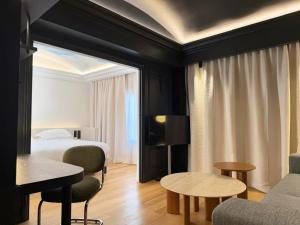 a hotel room with a bed and a couch and tables at Hotel Le Mathurin in Paris