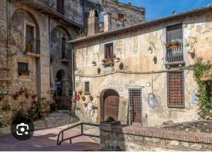 an old stone building with flowers in the window at AL CANTINONE in Toffia