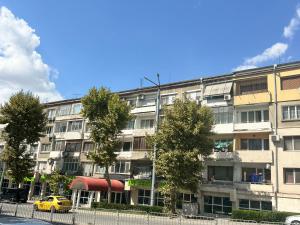 an apartment building with a yellow car parked in front of it at Апартамент Кари in Yambol