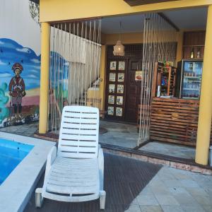 a white chair sitting next to a swimming pool at Pousada Mangai in João Pessoa