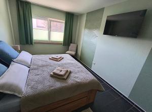 a bedroom with a bed and a flat screen tv at Ferienwohnung Grüne Oase in Lübbenau