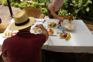 a man in a hat sitting at a table eating food at Penzion Vila Julie in Jilemnice +54 photos