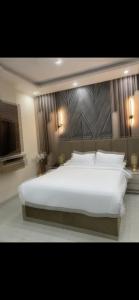 a bedroom with a large white bed with a large headboard at Tetou Hotel Cairo in Cairo