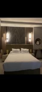 a bedroom with a large white bed with two lamps at Tetou Hotel Cairo in Cairo