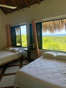 a bedroom with two beds and a large window at Villa del Mar in Zipolite +31 photos