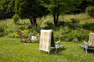 three chairs and a table in the grass at Penzion Vila Julie in Jilemnice