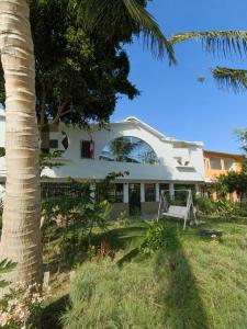 a white house with a palm tree in the foreground at Hospedaje Cocos House Talara - amplias habitaciones, Buena Ubicacion in Talara