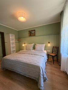 a bedroom with a large bed and a chair at Misses Greenday in Bad Suderode