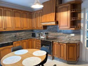 a kitchen with wooden cabinets and a table with chairs at A Casa do Miradoiro in Puentedeume