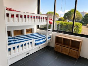 two bunk beds in a room with windows at Le Spot - Capbreton - Au calme et à deux pas de la mer in Capbreton