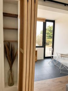 a room with a glass door and a table at Le Spot - Capbreton - Au calme et à deux pas de la mer in Capbreton