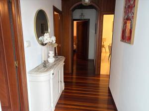 a hallway with a vase of flowers on a counter at A Casa do Miradoiro in Puentedeume +19 photos