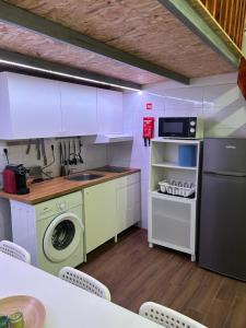 a kitchen with a washing machine and a washer at Sky carvoeiro in Mação