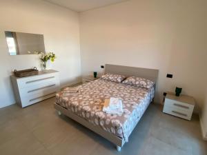 a bedroom with a bed and a dresser and a mirror at Brezza di Bari, Terrace & Free Parking, family and group apartment by Leviora Collection in Bari