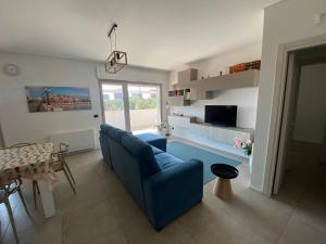 a living room with a blue couch and a table at Brezza di Bari, Terrace & Free Parking, family and group apartment by Leviora Collection in Bari