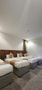 three beds are lined up in a room at فندق دار المتكاملة 4 in Al Khansāk