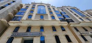 a tall building with a sign on it at فندق دار المتكاملة 4 in Al Khansāk