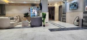 a lobby with couches and plants in a building at فندق دار المتكاملة 4 in Al Khansāk