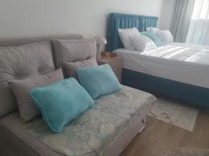 a couch with two pillows on it in a bedroom at Apartmani Zoka in Niš