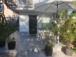 a house with a porch with potted plants at Apartmani Zoka in Niš