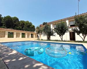 a swimming pool with two inflatable spheres in front of a building at La Llar del Magraner in Barraca de Aguas Vivas