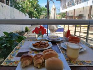 a table with plates of food and a glass of orange juice at Pousada Caliandra Pipa in Pipa